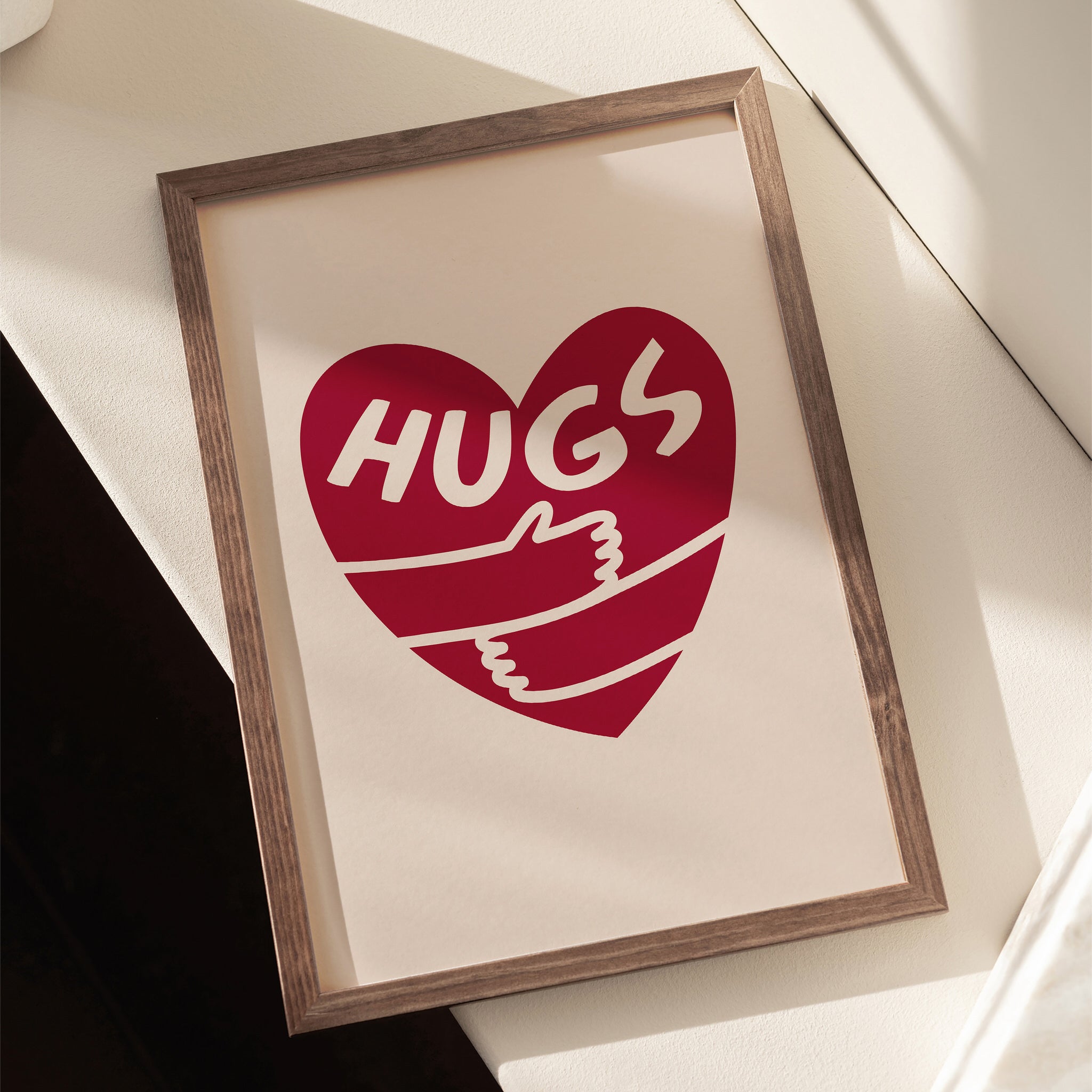 Minimalist print with red heart, hugging arms, and 'Hugs' text on beige